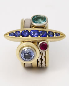 'Stacking Ring' in 18K yellow and white gold with lozenge shaped bridge feature set with seven round blue Sapphires